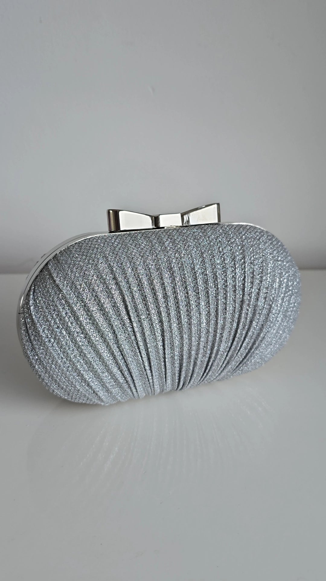 Sparkly silver bow top clutch bag